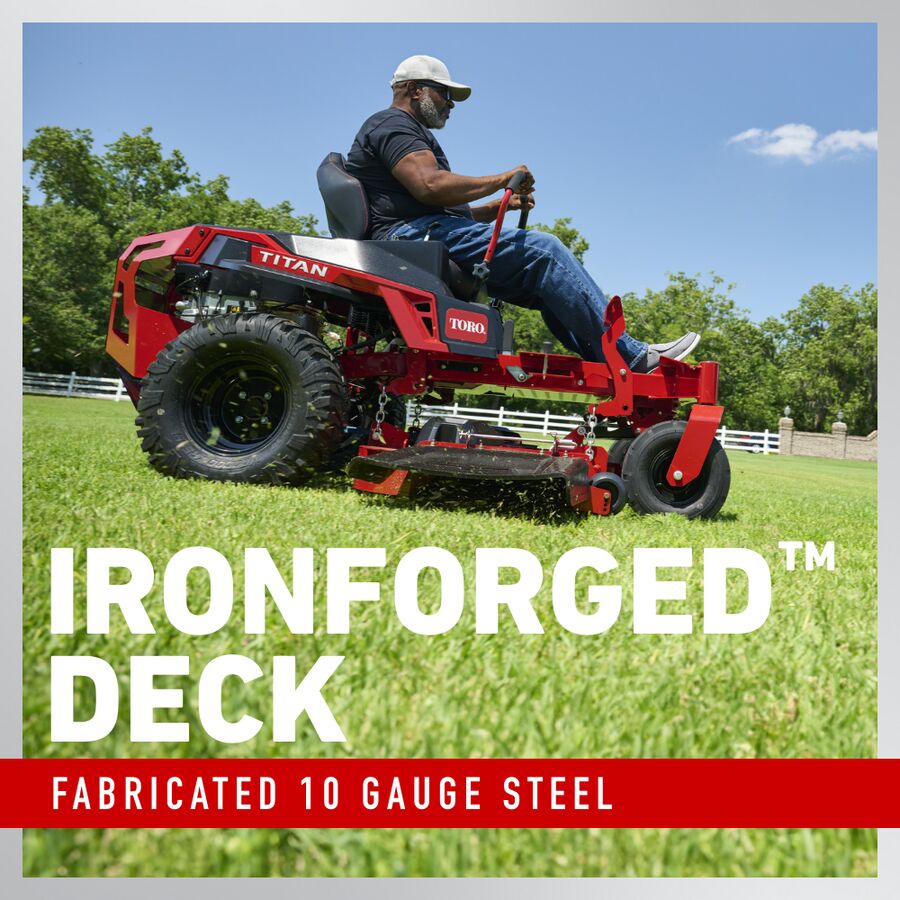 Person operating a red Toro lawn mower with 'IronForged Deck' text on a grassy field.